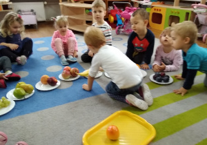 Dzieci segregują owoce według rodzaju.